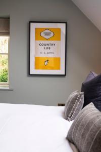 a framed picture on a wall above a bed at The Bottle & Glass Inn - Garden View - Room 1 in Henley on Thames