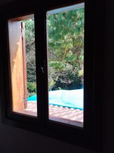 a window with a view of a pool seen through it at Quinta Meneses in Santa Cruz