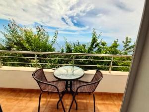 a glass table and two chairs on a balcony at Sea View in Dhermi in Gjilek