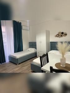 a small room with two beds and a table and a table sidx sidx at Marra’s Rooms in Durrës