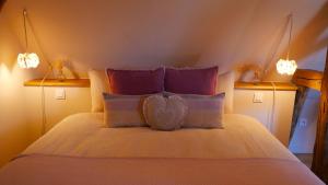 a bedroom with a bed with purple and purple pillows at Hissele in Hilsenheim