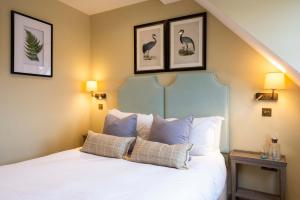 a bedroom with a white bed with pictures on the wall at The Bottle & Glass Inn - Barn View - Room 2 in Henley on Thames