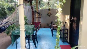 a porch with a hammock and a table and chairs at Quiet Place villa with kitchen in Tangalle