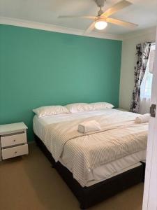 ein Schlafzimmer mit einem Bett und einem Deckenventilator in der Unterkunft Oxley's Rest in Harrington