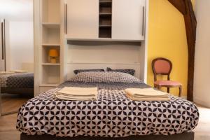 a bedroom with a bed with a black and white comforter at Lorette in Le Veurdre