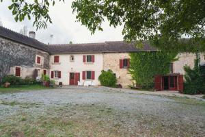 an old stone house with red doors and ivy at Lorette in Le Veurdre