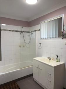 ein Badezimmer mit Badewanne, Waschbecken und Dusche in der Unterkunft Oxley's Rest in Harrington + 14 Fotos
