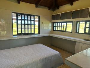 a bedroom with a bed and two windows at Las Dalias in Tacuarembó