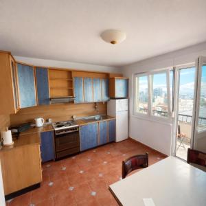 a kitchen with blue cabinets and a large window at Above the City, walk everywhere - 2BR, 2 Baths in Skopje
