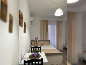 a room with a bed and a table and chairs at Marra’s Rooms in Durrës