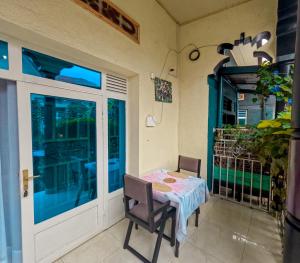 a patio with a table and chairs and a glass door at Saish Stay in Ruhengeri