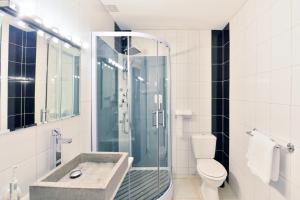 a bathroom with a shower and a sink and a toilet at Contact Hotel Le Moulin Neuf Chantonnay in Chantonnay +4 photos