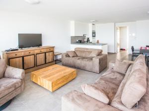 a living room with couches and a flat screen tv at Les Amiraux - 0701 + box 2 in Westende-Bad