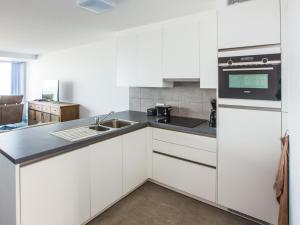 a kitchen with white cabinets and a sink at Les Amiraux - 0701 + box 2 in Westende-Bad