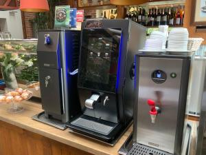 Eine Kaffeemaschine und ein Laptop stehen auf einer Theke. in der Unterkunft Maestro Inn in Krasnystaw