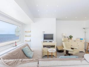 a living room with a couch and a tv and a window at Trianon - 0609 in Westende-Bad