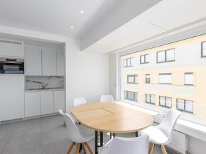 a kitchen and dining room with a wooden table and white chairs at Trianon - 0609 in Westende-Bad