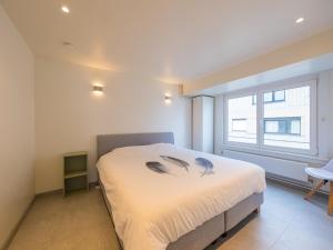 a bedroom with a bed with feathers on the bedspread at Trianon - 0609 in Westende-Bad