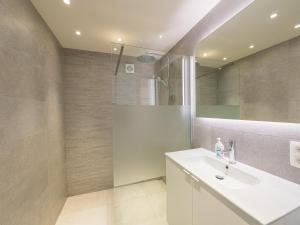 a bathroom with a white sink and a shower at Trianon - 0609 in Westende-Bad +8 photos
