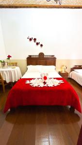 a bedroom with a bed with a red blanket at POUSADA PARLATORIUM in Tiradentes