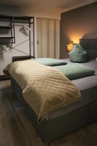 a bedroom with two beds and a lamp at Landhaus Sonnenwinkel in Brodenbach