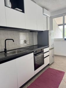 a white kitchen with a sink and a refrigerator at Apartment Anka Polače in Polače