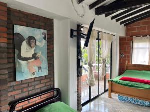 a bedroom with a bed and a painting on the wall at Hotel Montañitas in Guatapé +56 photos