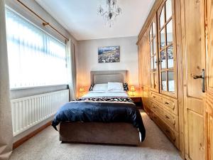 a bedroom with a bed and a large window at Ma Monaghan's Cosy Cottage County Tyrone in Pomeroy