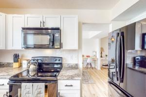 a kitchen with white cabinets and a stove top oven at Indy Home w/ Dog-Friendly Yard! 9 Mi to Dtwn in Spring Hollow