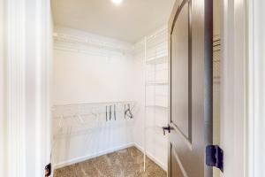 a walk in closet with white walls and a door at Indy Home w/ Dog-Friendly Yard! 9 Mi to Dtwn in Spring Hollow +27 photos