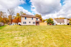 a large yard with a white house and a house at Indy Home w/ Dog-Friendly Yard! 9 Mi to Dtwn in Spring Hollow