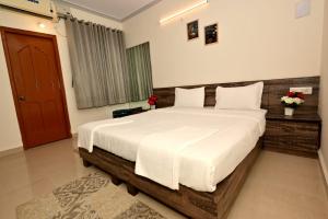 a bedroom with a large bed with white sheets at Scandi-Stay 2BR by Benaulim Beach in Benaulim +17 photos