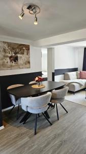 a dining room with a black table and chairs at Sauerland Apartments in Schwalefeld