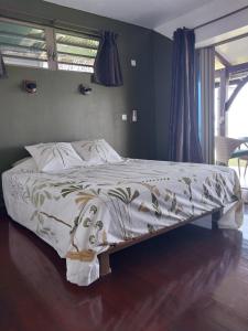a bedroom with a bed with a white comforter at Faré Mahi Mahi in Uturoa