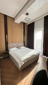 a bedroom with a large bed and a window at Alatau hotel in Shymkent
