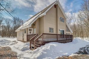 a house with a porch in the snow at Contemporary House in Lakeside Community! Poconos in Albrightsville
