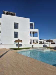 a white building with a swimming pool in front of it at LA Paz - Sunny Pool Retreat - Jacuzzi - Near Beach in Los Alcázares