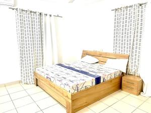a bedroom with a wooden bed and curtains at Havre de paix prestige in Midja