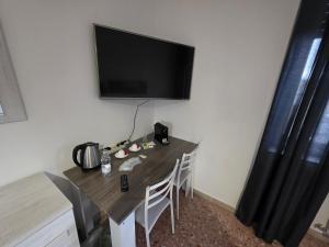 a table with chairs and a television on a wall at Home Lazio 36 in Cosenza