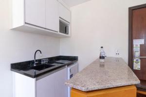 a kitchen with a sink and a counter top at Hotel Flat Petras Residence in Curitiba