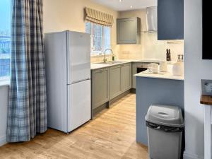 a kitchen with a refrigerator and a sink at Pine View Cottage in Filey +14 photos