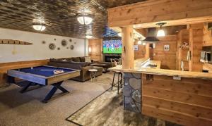 a living room with a pool table in the middle of it at Eagle Pine Lodge in Custer