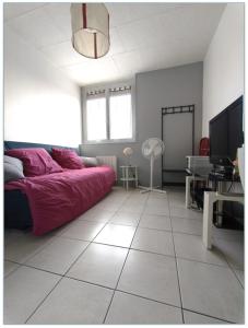 a living room with a red couch on a tiled floor at Studio au calme in Péronnas