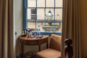 a table and a chair in a room with a window at The Ancient Gatehouse & Rugantino Restaurant in Wells