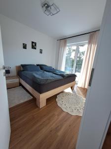 a bedroom with a bed and a large window at Ferienwohnung Hahnenblick in Hahnenbach +11 photos