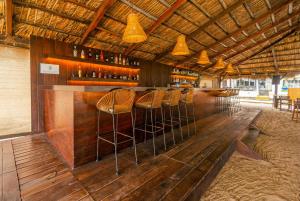 un bar con taburetes de madera en un restaurante en Artisan Playa Esmeralda Family Beach Hotel, en Chachalacas