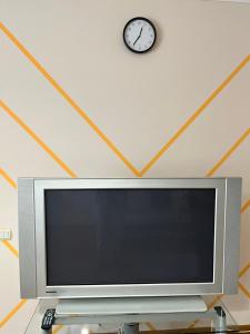 a flat screen tv with a clock on the wall at Центр, 2х комнатная студио возле парка, WIFI in Vinnytsya