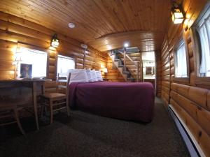 a bedroom with a bed in a wooden cabin at Red Caboose Motel & Restaurant in Ronks