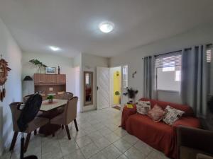 a living room with a red couch and a table at Espaço do acalanto- Quarto em apartamento compartilhado in Natal