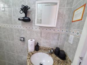 a bathroom with a sink and a mirror at Espaço do acalanto- Quarto em apartamento compartilhado in Natal +23 photos